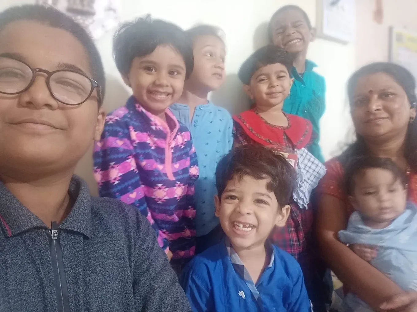 Kaku taking a happy selfie with a group of smiling children