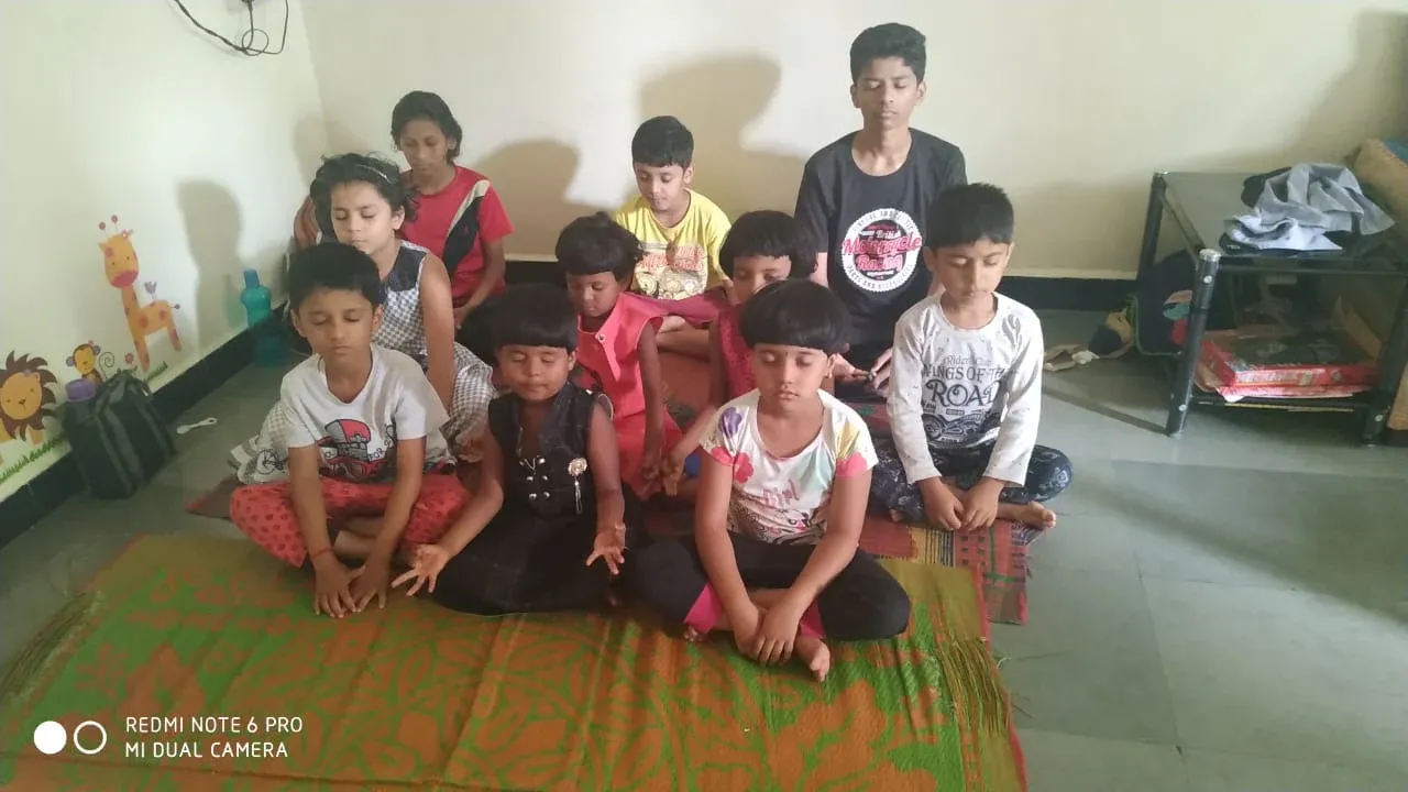 Children sitting cross-legged with closed eyes during meditation time