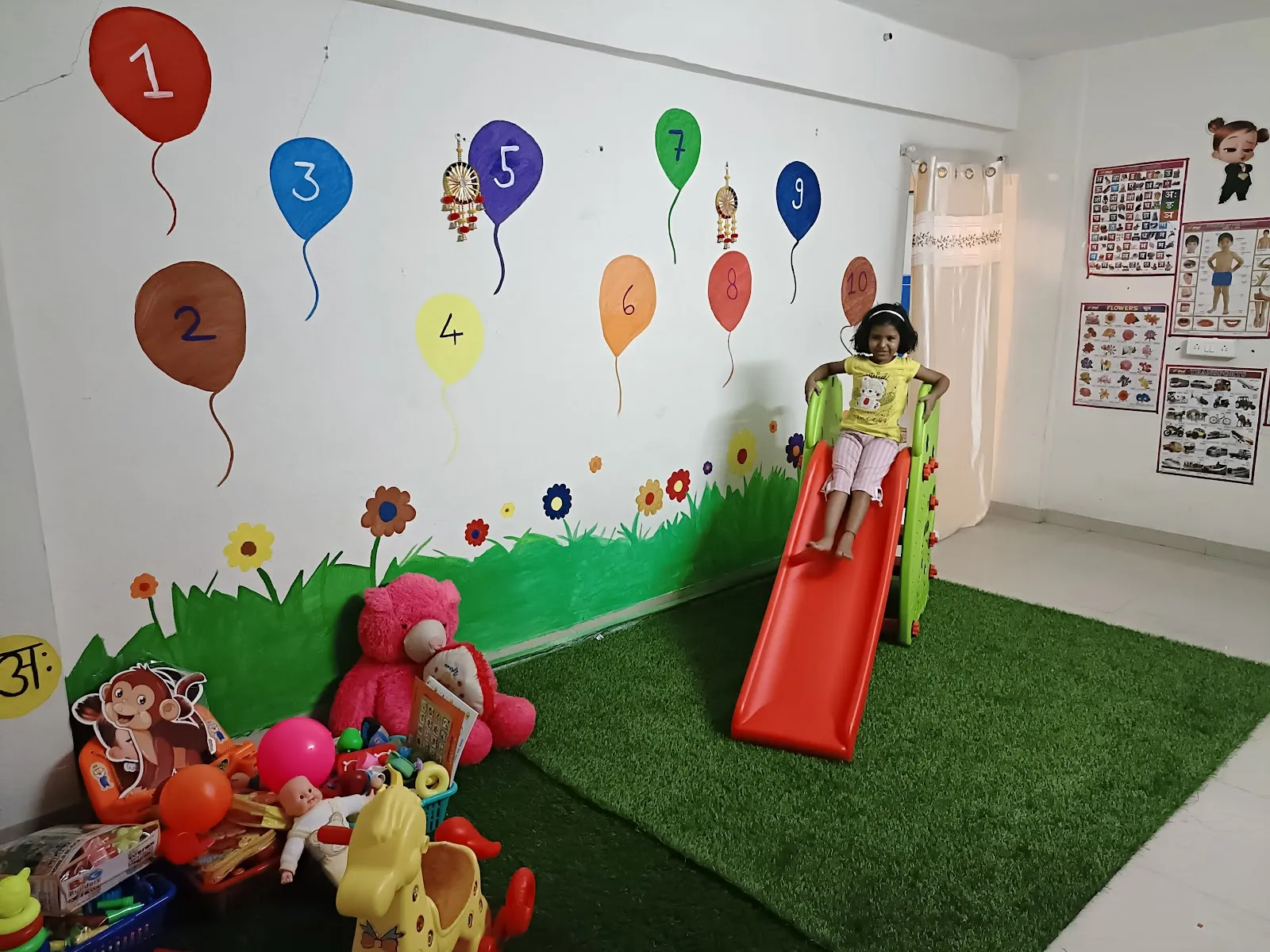 Maza Ghar indoor play room with a slide, soft toys and a hand-painted number-balloons wall